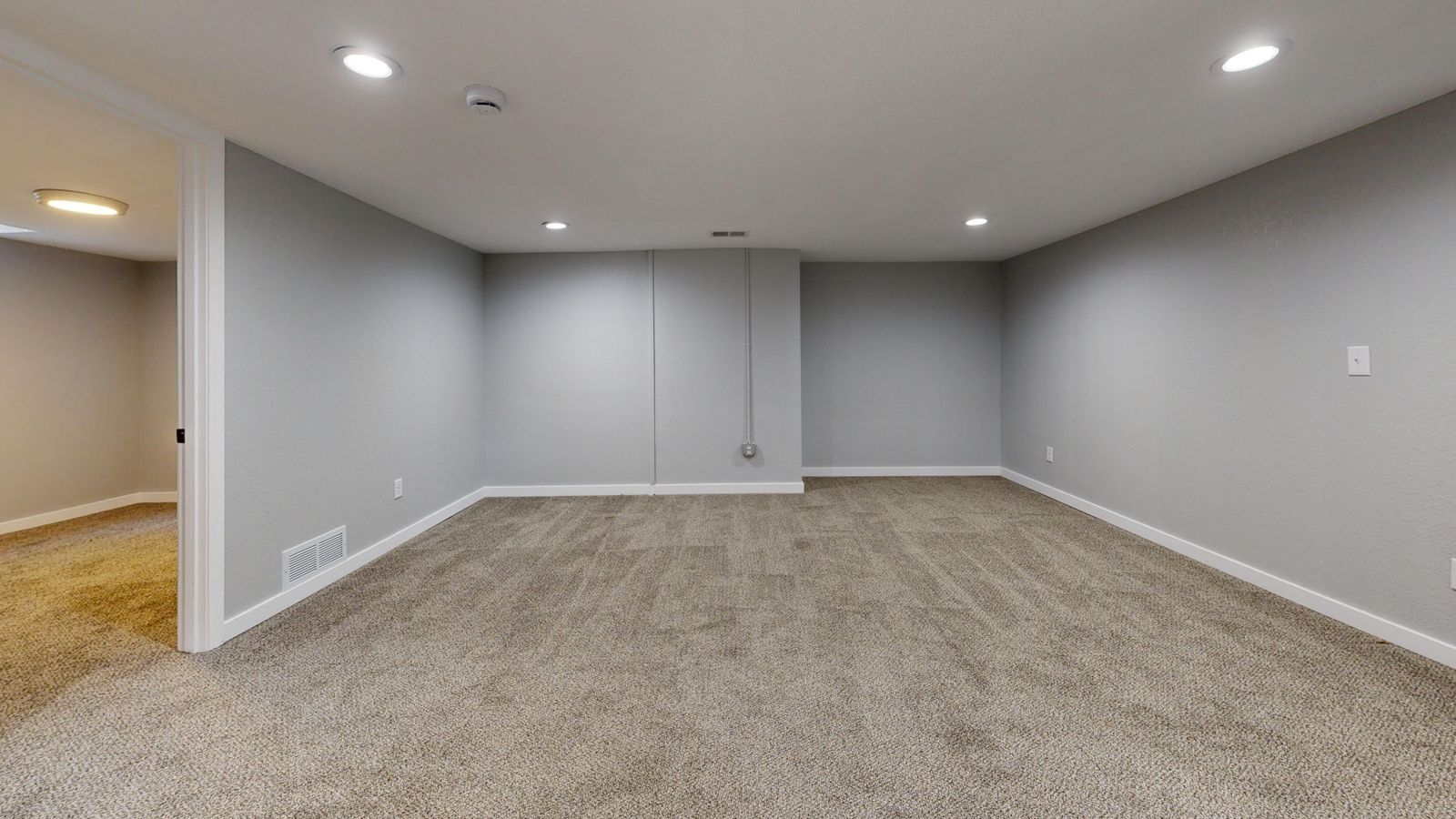 Open basement room with neutral walls ready for finishing