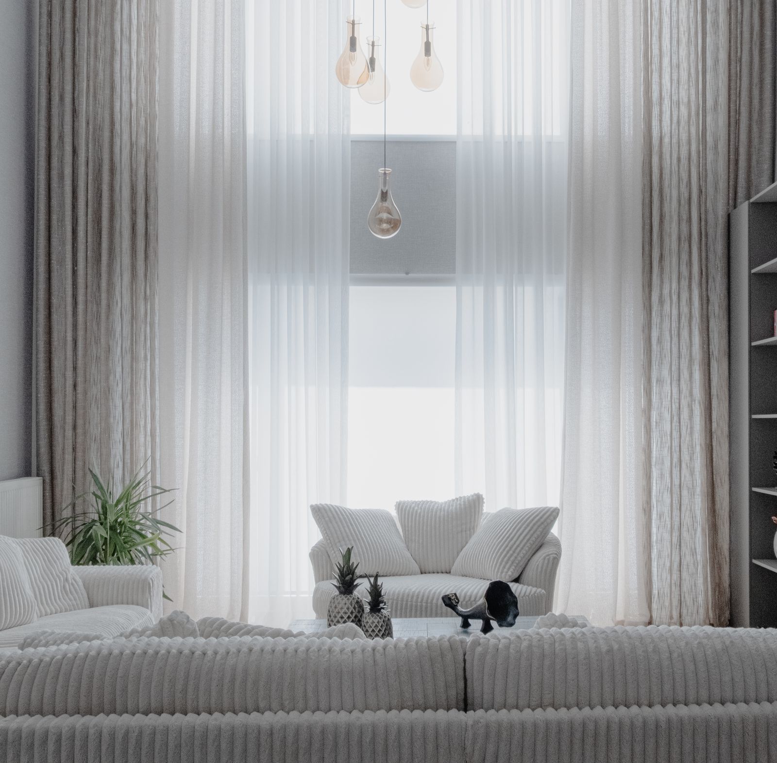 Minimalist living room with white sofas and full-length curtains